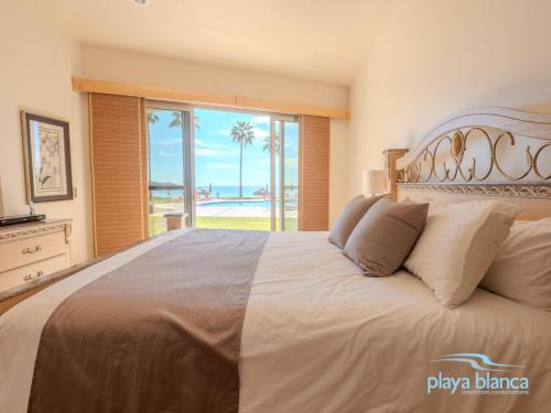 Schlafzimmer mit einem großen Bett und Strandblick in der Unterkunft Playa Blanca Premier Unit 103 in San Carlos