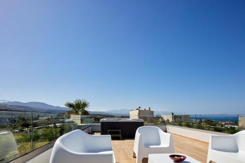 a view from the balcony of a house with white chairs at Manza Villa in Sfakaki