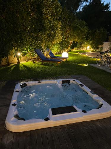 a hot tub on a deck in a yard at night at Villaaquamarina in Torre dell'Orso