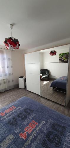 une chambre avec un lit et un grand miroir dans l'établissement Appartement idéal au calme !, à Hadol