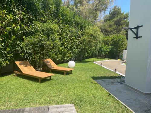 two benches sitting on the grass in a yard at Villaaquamarina in Torre dell'Orso