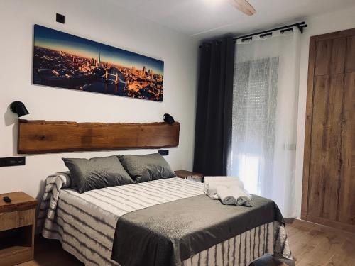 ein Schlafzimmer mit einem Bett und einem Bild an der Wand in der Unterkunft Villas de lujo con Chimenea y Vistas Panorámicas a la Sierra de Cazorla in Pozo Alcón