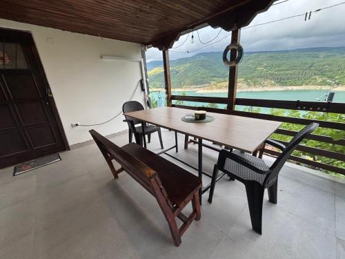 a table and chairs on a balcony with a view at Lake View Cottage - Zavojsko jezero in Zavoj
