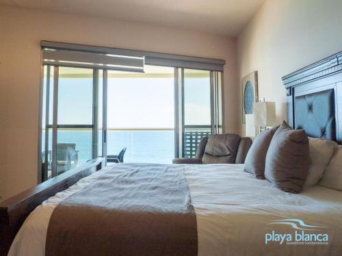 a bedroom with a large bed with a view of the ocean at Playa Blanca Premier Unit 1302 in San Carlos