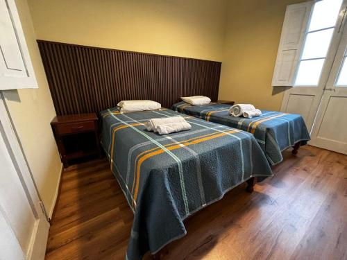 two beds with towels on top of them in a room at Olespier Hostel in Arequipa