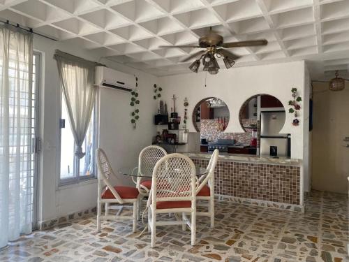 a kitchen with a ceiling fan and a table and chairs at Departamento sobre Costera, 1min La Quebrada, 3m playas y yates in Acapulco