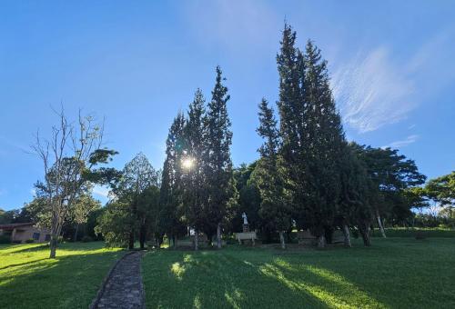 a path in a field with trees and a sky at Siloe Hotel by Concavus in Vinhedo