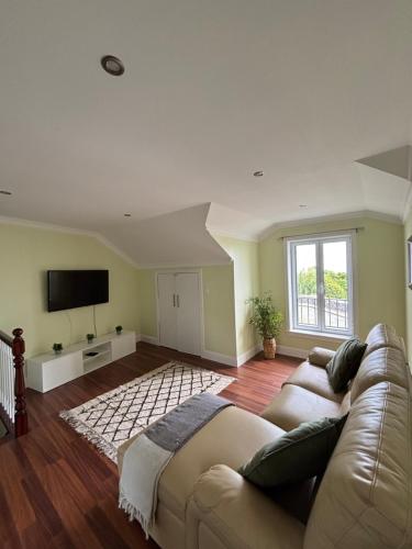 a living room with a couch and a flat screen tv at Casa da Ribeira - Azores in Ponta Garça