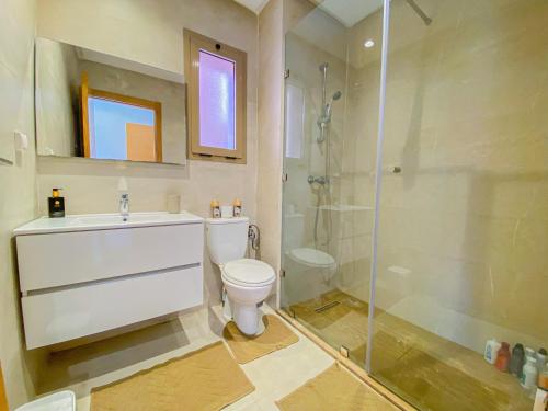 ein Badezimmer mit Dusche, Toilette und Waschbecken in der Unterkunft Luxury Apartment in Prestigia Marrakech in Marrakesch