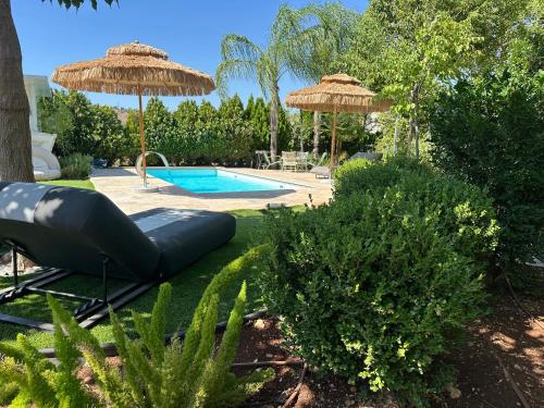 a backyard with a pool and umbrellas and a swimming pool at איול Ayul in Sede Eli‘ezer