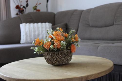 a vase of orange flowers sitting on a coffee table at Apartman Humac in Otočac