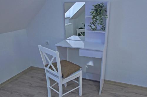 a white desk with a chair and a mirror at Apartman Humac in Otočac