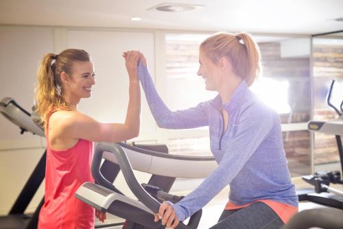 two women on a treadmill in a gym at Dorint Am Nürburgring Hocheifel in Nürburg