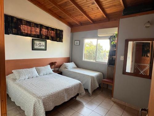 Un dormitorio con dos camas y una ventana. en El Portal, en Posadas
