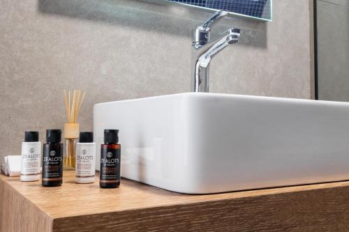 a bathroom sink with five bottles ofodorizers on a counter at Emerald Oasis By Azul Collection in Pigianos Kampos