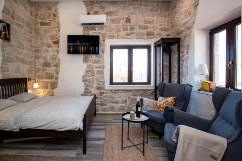 a bedroom with a bed and a couch and a table at Studio DIAMADI-Old Town Rovinj in Rovinj