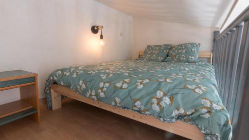 a bedroom with a bed with a green comforter at Studio - Les Capucins in Riom