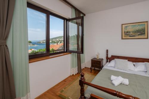 a bedroom with a bed and a large window at Kuća 100m od mora - Drvenik Veli in Veliki Drvenik
