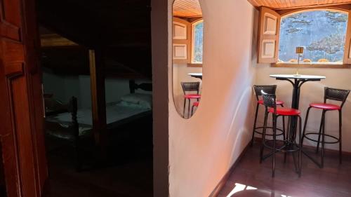 a room with two bar stools and a bed at Hostel do Mirante in Ouro Preto