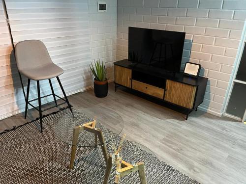 a room with a television and a chair and a table at Casa equipada Vallenar in Huasco