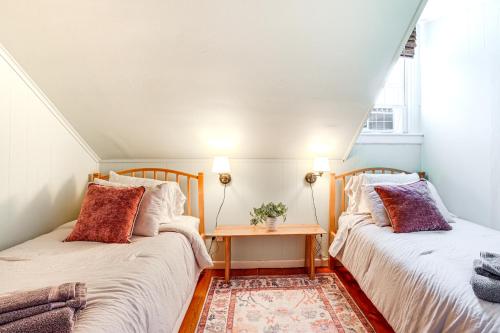 ManchesterにあるWalk to the T North Shore Retreat Near Salem Fun!のテーブル付きの小さな部屋のベッド2台