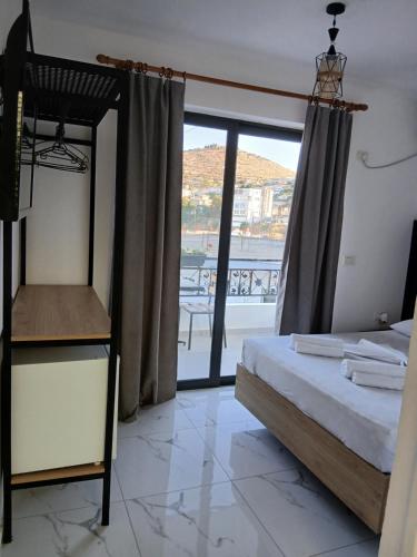 a bedroom with a bed and a view of a balcony at Villa Allkushi in Sarandë