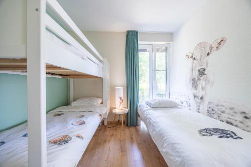 a bedroom with two bunk beds and a deer on the wall at De Weldoeninge in Wingene