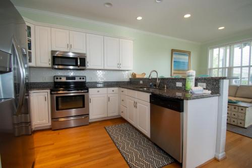 a kitchen with white cabinets and stainless steel appliances at 83 Ocean Creek Blvd in Fripp Island