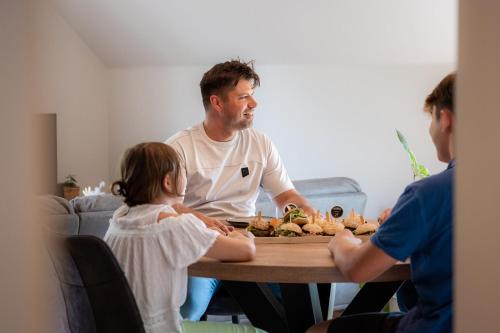a man sitting at a table with a little girl at De Weldoeninge in Wingene
