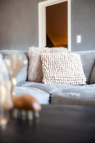 a pillow on a couch in a living room at De Weldoeninge in Wingene
