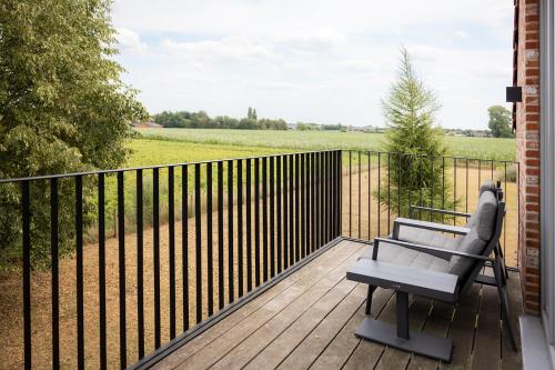 a bench on a wooden deck with a fence at De Weldoeninge in Wingene