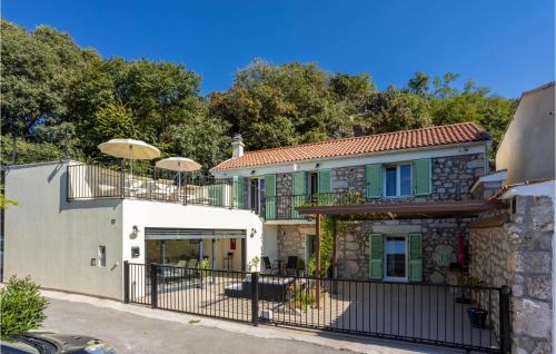 a house with a balcony and a fence at Cozy Home In Grizane-Belgrad in Grižane
