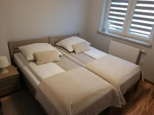 two beds sitting next to each other in a bedroom at Apartament z tarasem in Bodzentyn