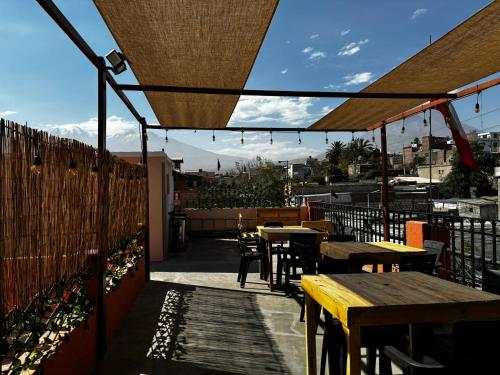 a patio with tables and chairs and a fence at Olespier Hostel in Arequipa