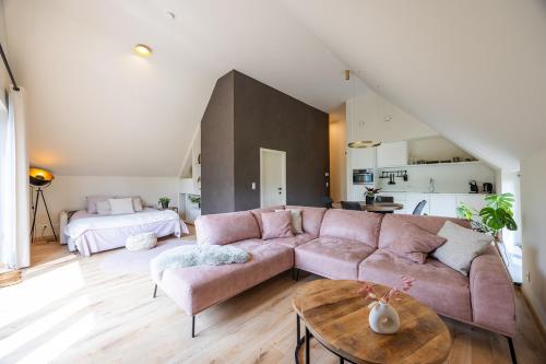 a living room with a pink couch and a bed at De Weldoeninge in Wingene