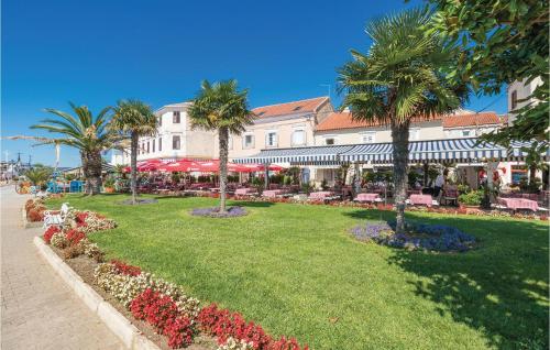 a resort with palm trees and a lawn with flowers at Amazing Home In Sveti Filip I Jakov in Sveti Filip i Jakov