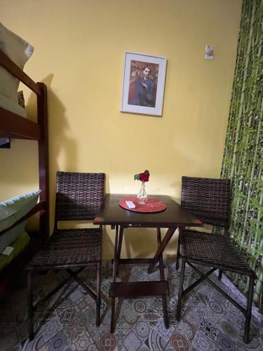 a table with two chairs and a table with flowers on it at Pousada Morango das Palmas in Praia de Palmas