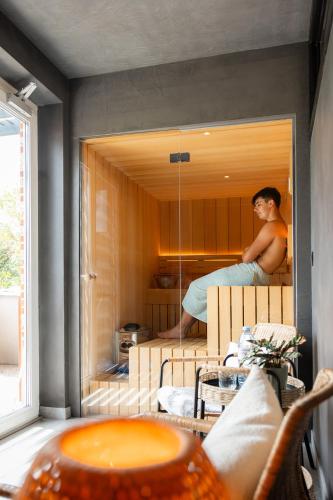 a man sitting on a bed in a room at De Weldoeninge in Wingene