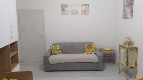 a living room with a gray couch and a table at Monolocale in vicolo storico Gin Tonic Lemon in Rodi Garganico