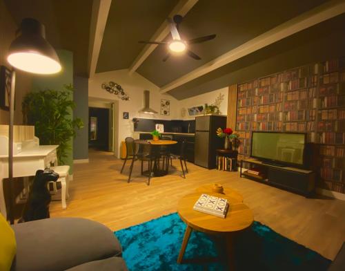 Una sala de estar con un sofá y un televisor. en La Maison Zébulon, en Saint-Vincent-de-Paul