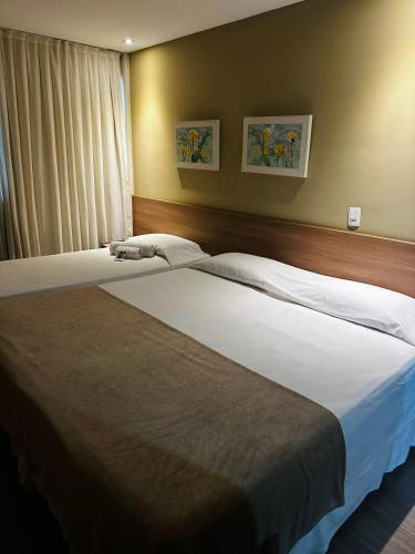 a bedroom with two beds and a window at Mont Blanc Suites Duque de Caxias in Duque de Caxias