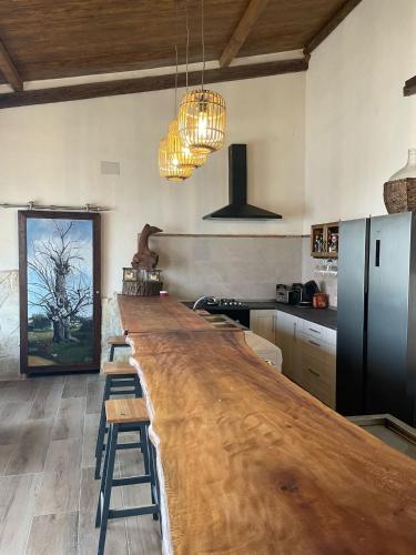 a large kitchen with a long wooden bar in it at Casa Los Templarios, cerca de Puy du fou in Burujón