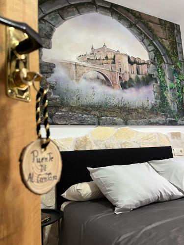 a bedroom with a painting of a bridge and a bed at Casa Los Templarios, cerca de Puy du fou in Burujón