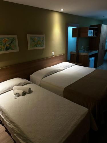 a hotel room with two beds with towels on them at Mont Blanc Suites Duque de Caxias in Duque de Caxias