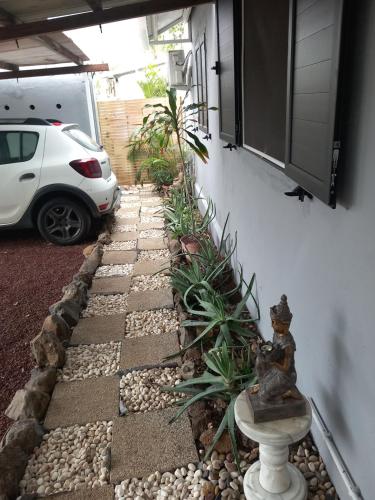 a garden with a car parked next to a house at Aloes Lagoon Lodge in Saint-Paul