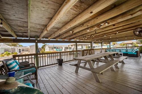 a wooden deck with a picnic table and chairs at Canal Front Beach Home, Private Pool in Flagler Beach