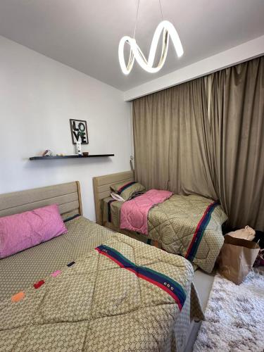 a bedroom with two beds and a chandelier at ريفا فيو in El Alamein