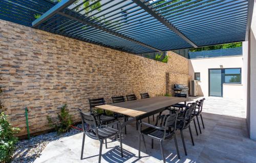 a patio with a table and chairs under a pergola at Lovely Home In Opric With Wifi in Opric