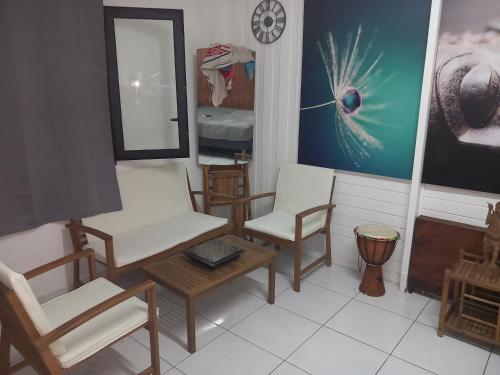 a room with chairs and a table and a mirror at Aloes Lagoon Lodge in Saint-Paul