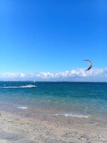 a kite flying over the ocean on a beach at Aloes Lagoon Lodge in Saint-Paul